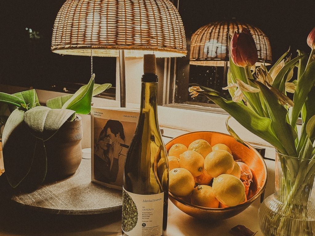 A desk with a lamp, a notebook and a bowl of lemons